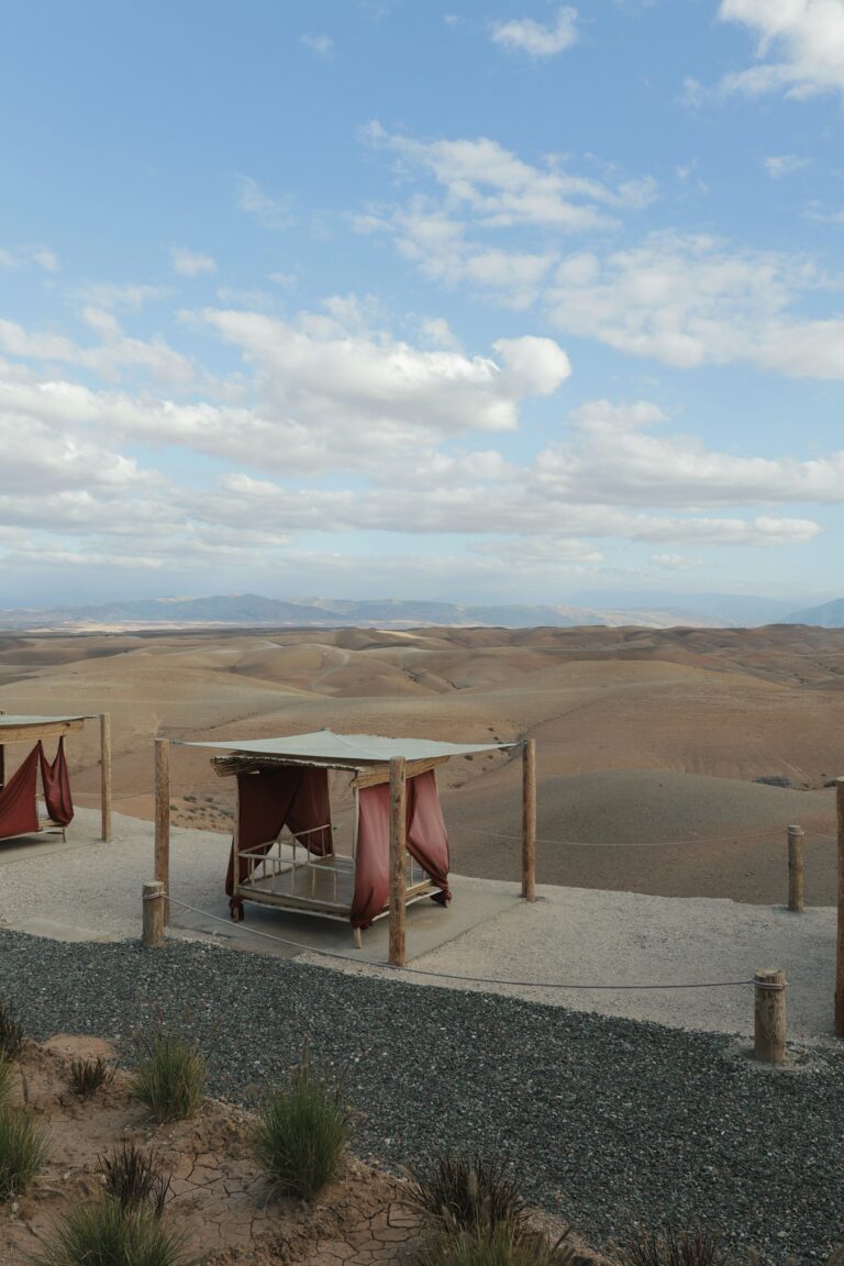 Outdoor daybeds overlooking the arid Agafay landscape under a blue sky
