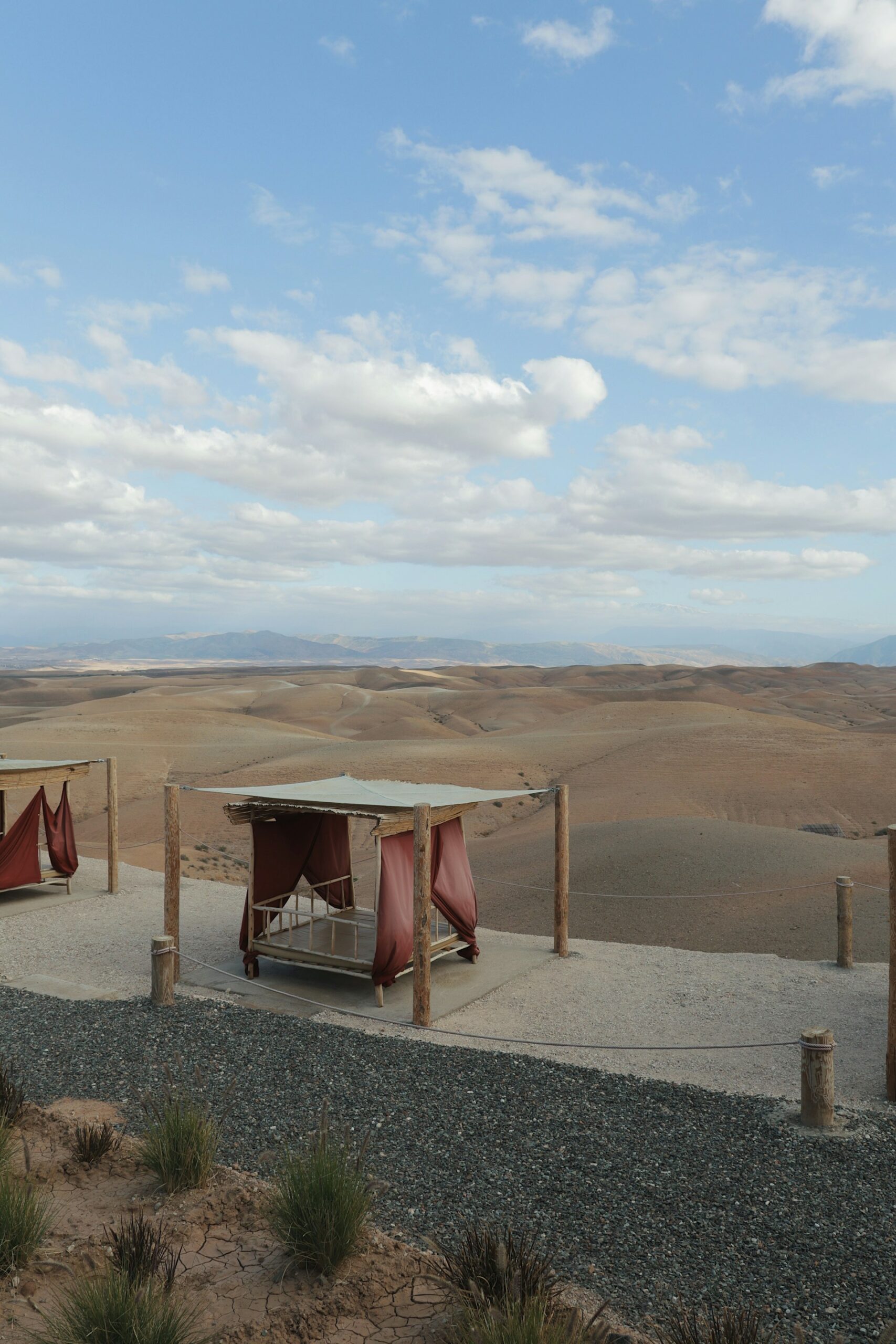 Outdoor daybeds overlooking the arid Agafay landscape under a blue sky