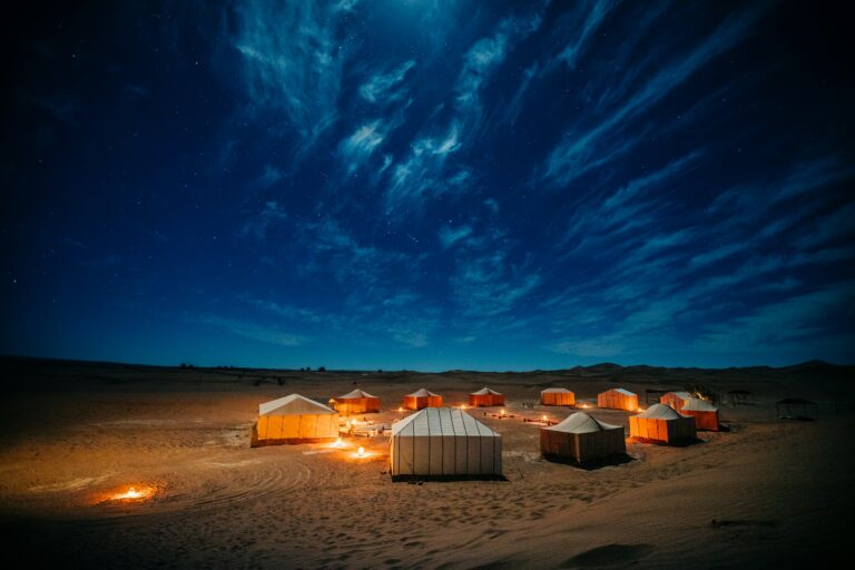 Desert camp tent under a deep blue night sky in the Sahara