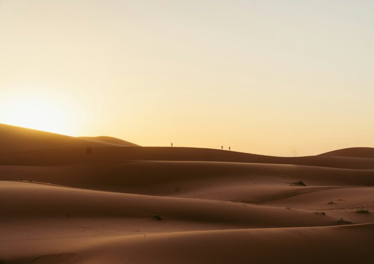 Golden sand dunes under a pale sky in the Moroccan desert