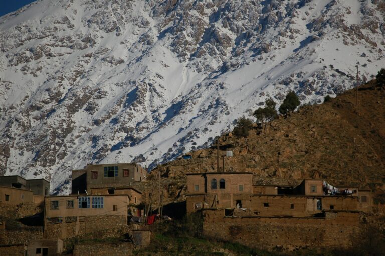 Mountain village building below the snow-covered High Atlas peaks