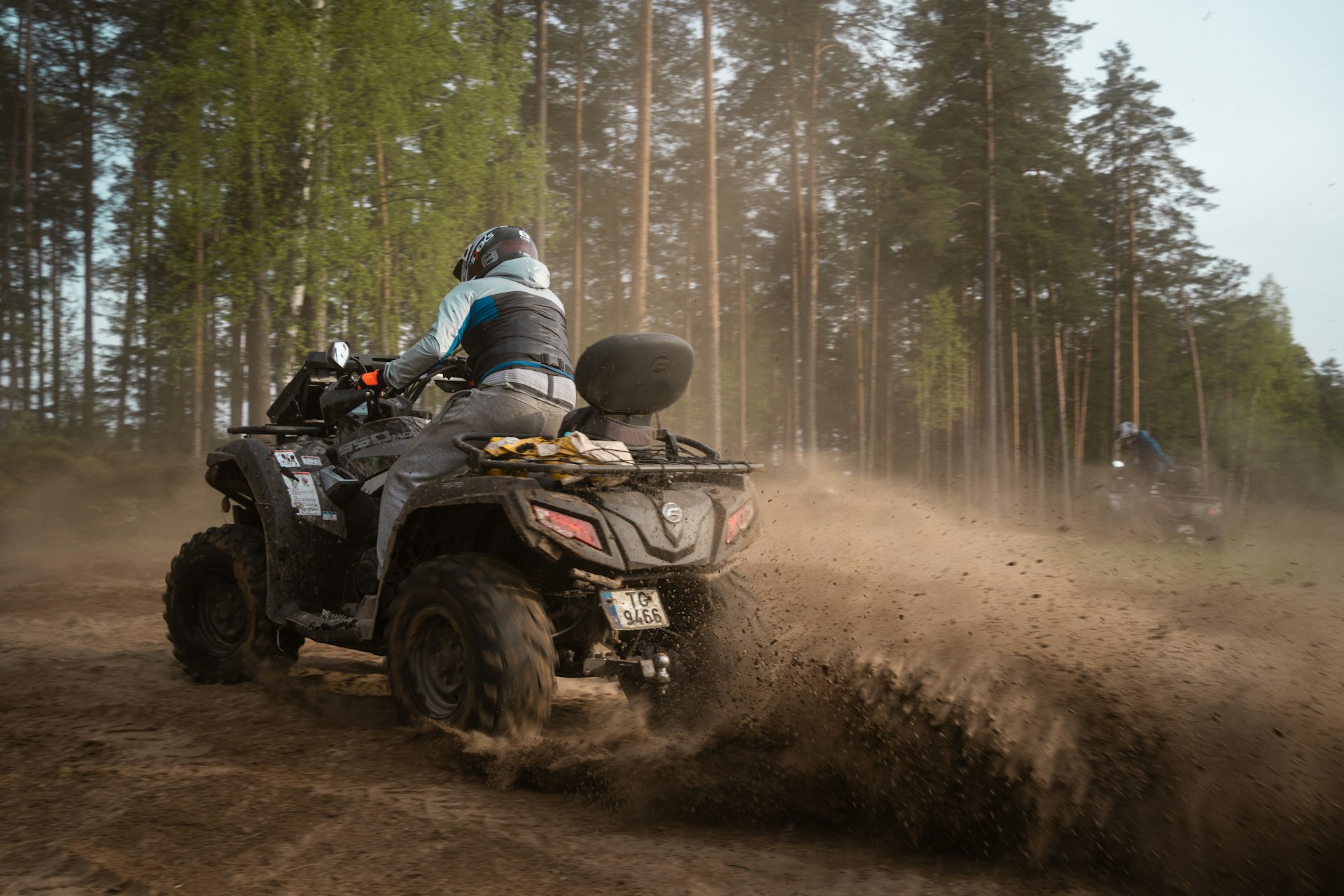 Rider on an all-terrain vehicle following a dirt track