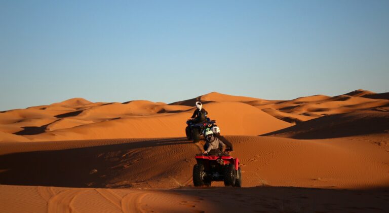 Rider on a quad bike crossing sandy desert terrain in Morocco