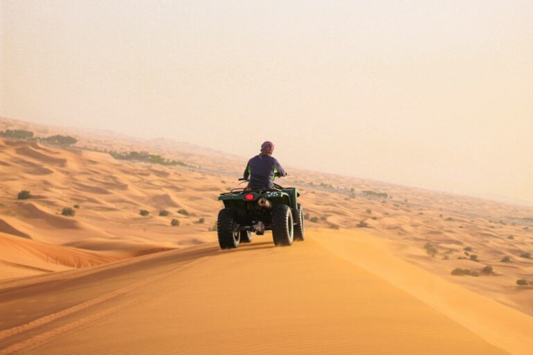 Rider on a black quad bike on golden sand